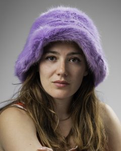 Close-up studio portrait of a woman in a fluffy lilac bucket hat