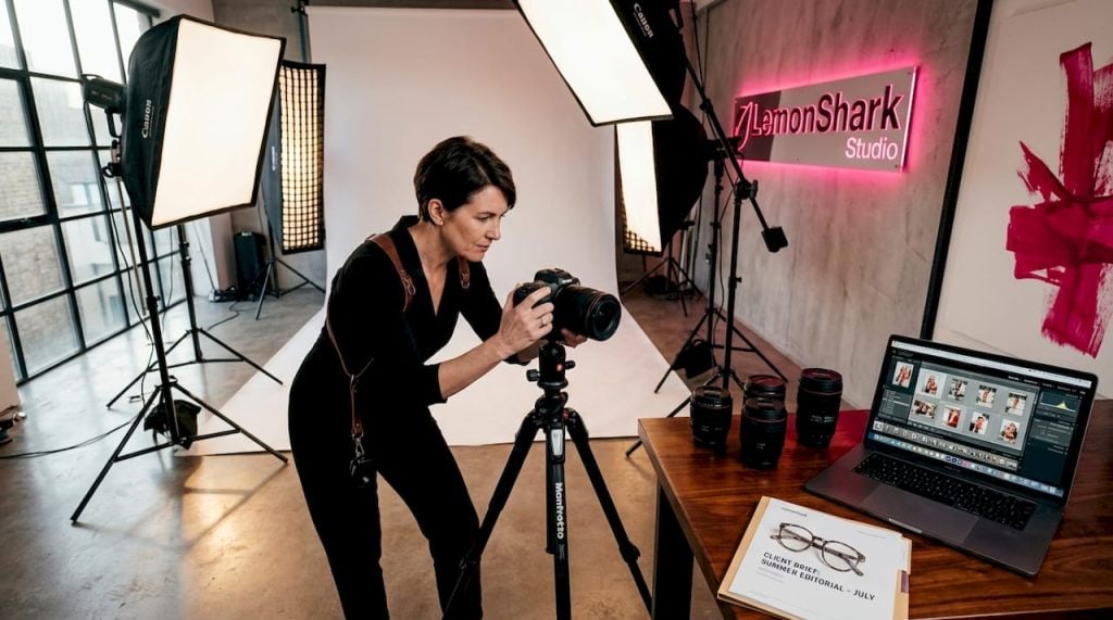 Professional photographer adjusting camera in studio
